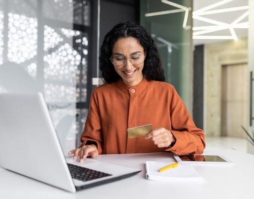 Women using a laptop to book tickets online for a global travel tour.