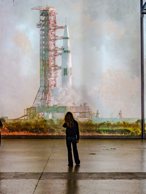 Visitors viewing rocket projection at The Moonwalkers Exhibition, Atelier des Lumières.