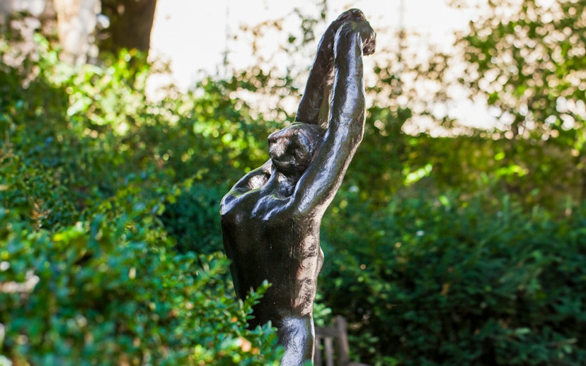 Sculpture in Rodin Museum garden surrounded by greenery.