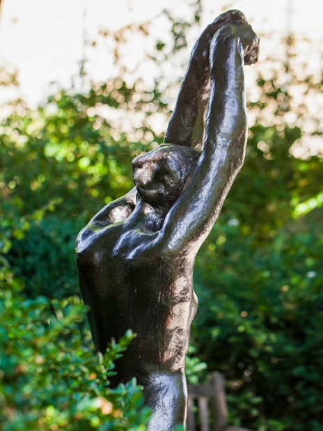 Sculpture in Rodin Museum garden surrounded by greenery.