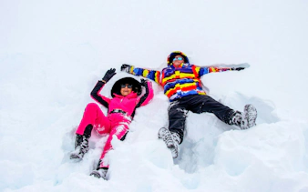 Tourists relaxing in snow at Valle Nevado ski resort, Andes Mountains, Chile.