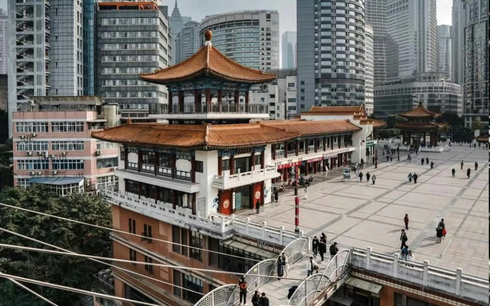 Kuixing Tower in Chongqing, China, surrounded by modern buildings and a busy square.
