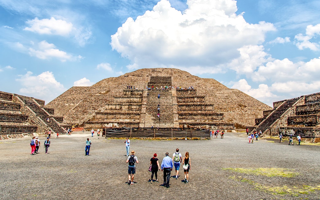 Visitors exploring the Pyramid of the Sun on a Teotihuacan Pyramids guided walking tour.