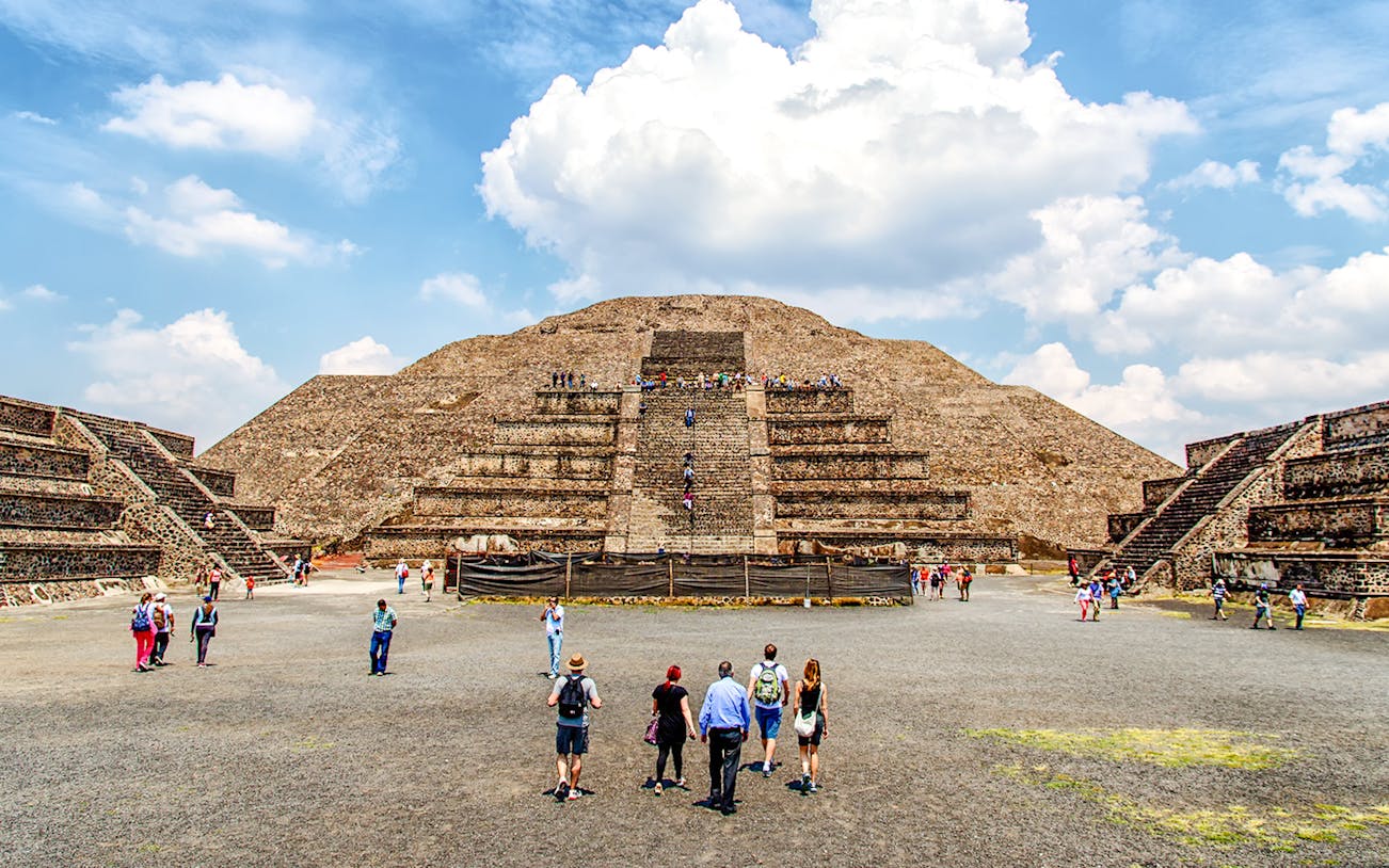 Teotihuacan Pyramids with tourists exploring ancient ruins on a guided walking tour in Mexico.