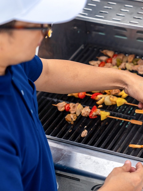 Grilling skewers with vegetables and meat at Dubai Marina yacht party BBQ.