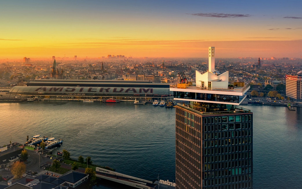 ADAM Lookout tower with Amsterdam skyline at sunset.