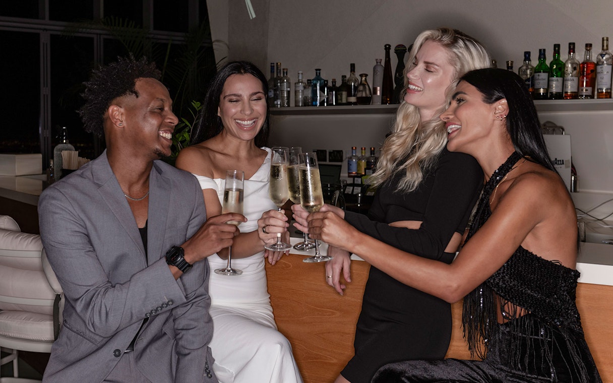 Group enjoying drinks at a bar near Aura Sky Pool.