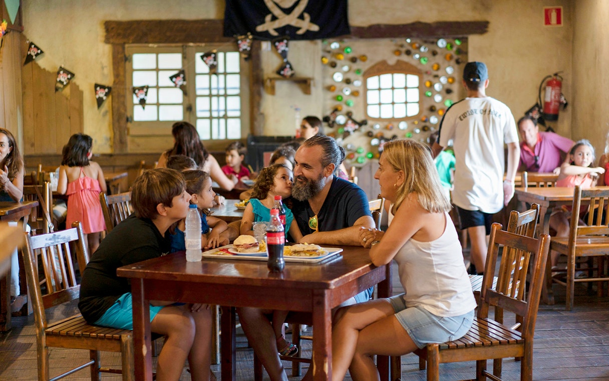 Family dining at Isla Mágica restaurant with pirate-themed decor.