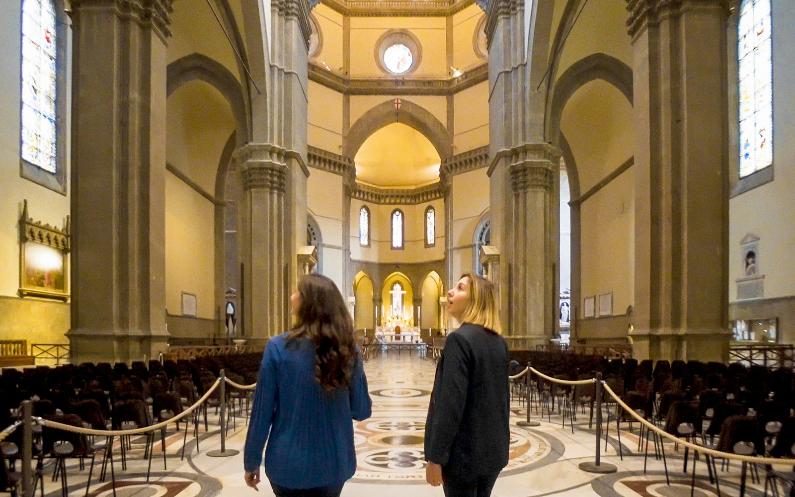 Visitors exploring the interior of Florence Duomo, Italy, admiring its architectural details.