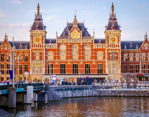 Amsterdam Central Train Station exterior with clock tower and historic architecture.