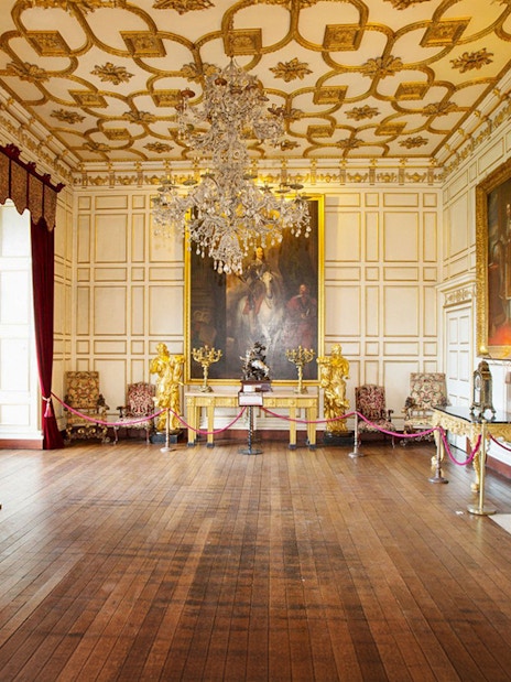 Warwick Castle interior with ornate paintings and chandelier on Stratford, Oxford, Cotswolds tour.
