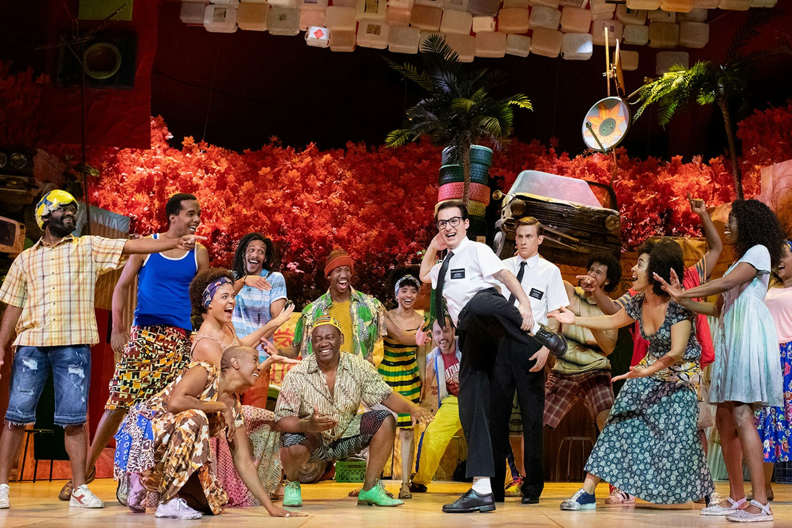 Performers on stage in a vibrant scene from "The Book of Mormon" musical.