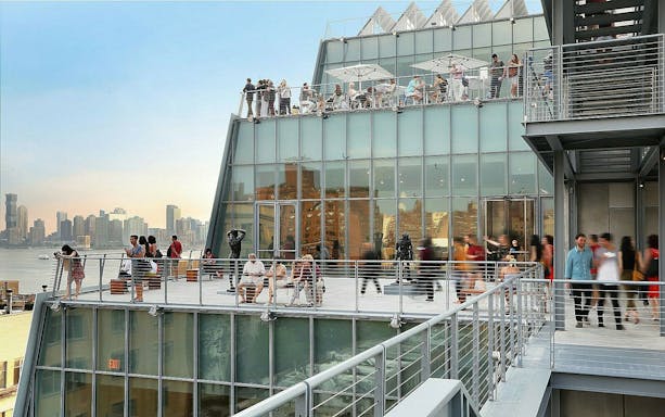 Visitors on the terrace of Whitney Museum of American Art with city skyline view.