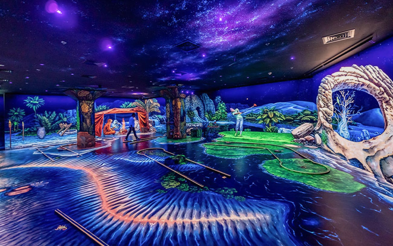 3D blacklight minigolf course in Dubai with cosmic and jungle-themed decor.