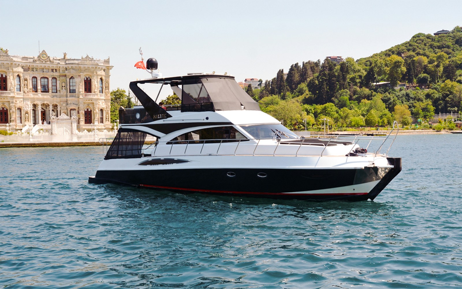 Luxury private yacht cruising on the Bosphorus with Istanbul skyline in the background.