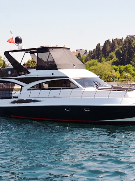 Luxury private yacht cruising near a historic palace on the Bosphorus, Istanbul.