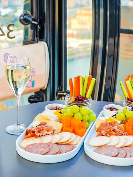 Singapore cable car dining with champagne, charcuterie, and city view.