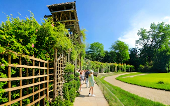 Visitors exploring gardens on the Versailles Golfcart & Bike Guided Tour.