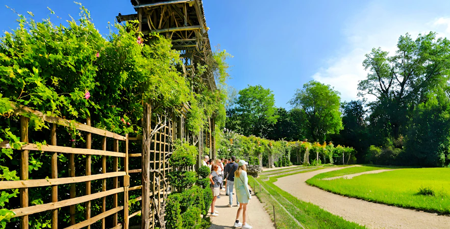 Visitors exploring gardens on the Versailles Golfcart & Bike Guided Tour.