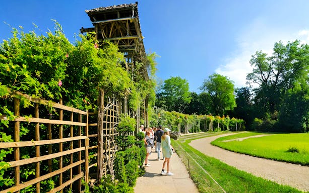 Visitors exploring gardens on the Versailles Golfcart & Bike Guided Tour.