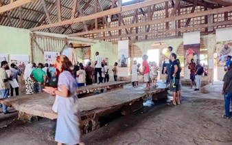 Visitors exploring a bustling fish market in Dar es Salaam during the Masaki Walking Tuk-Tuk Fish Market & Sunset Tour.