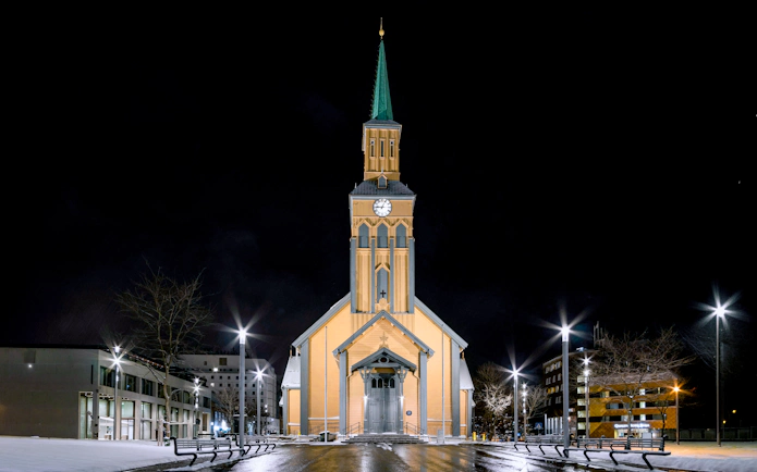 Tromsø Cathedral illuminated at night, venue for Arctic Music Experience concert.