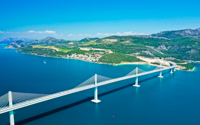 Aerial view of Pelješac Bridge spanning blue waters in Croatia.