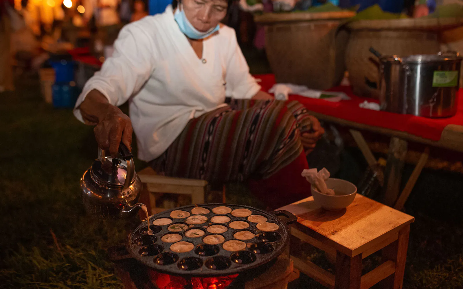 Person preparing traditional snacks at Yeepeng Lanna Festival 2023 in Thailand.