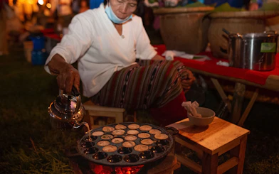 Person preparing traditional snacks at Yeepeng Lanna Festival 2023 in Thailand.