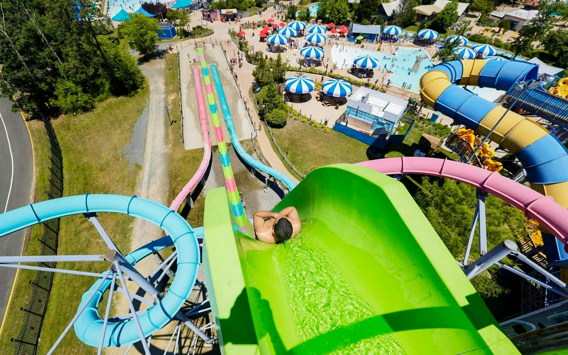 Water slide at Hurricane Harbor New Jersey with colorful tubes and pool area.