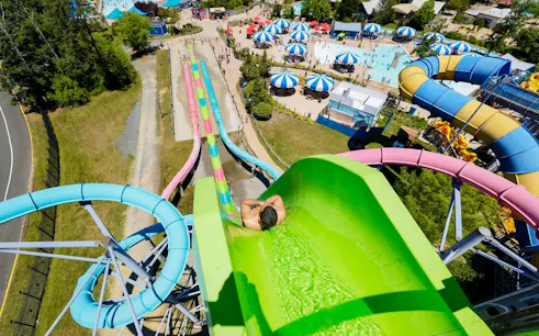 Water slide at Hurricane Harbor New Jersey with colorful tubes and pool area.