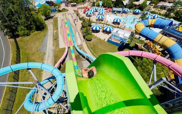 Water slide at Hurricane Harbor New Jersey with colorful tubes and pool area.