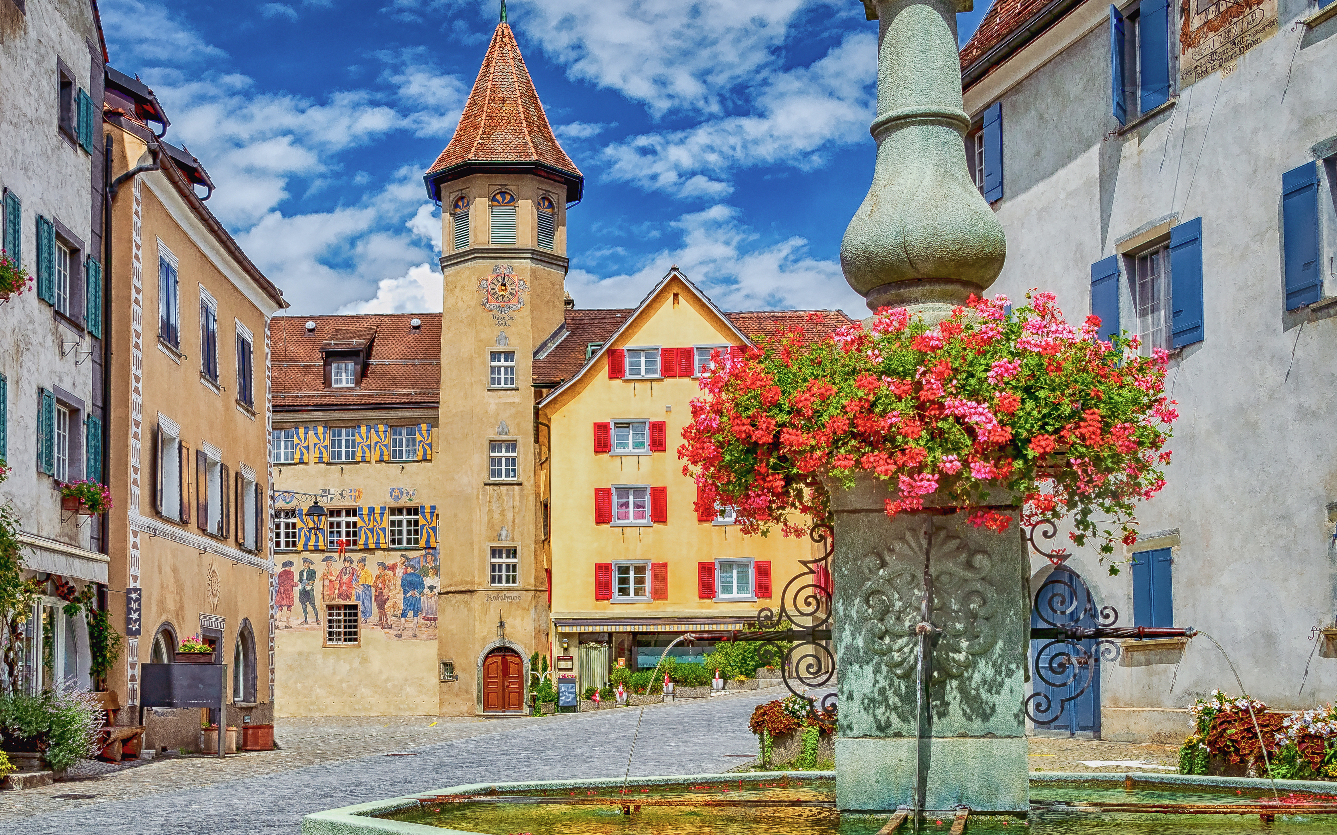 Town square with historic buildings and fountain in Maienfeld, Graubunden, Switzerland.