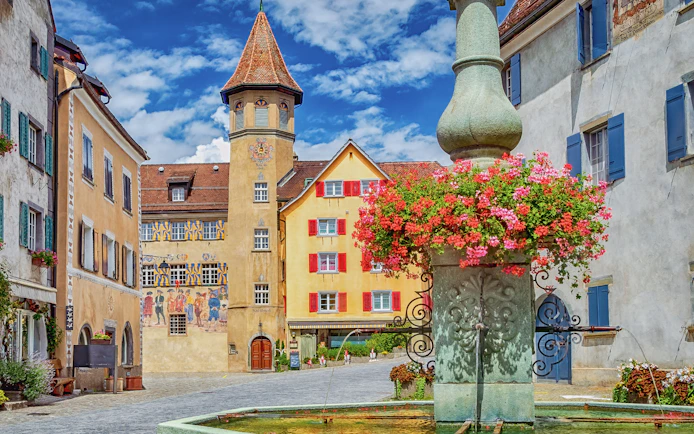 Town square with historic buildings and fountain in Maienfeld, Graubunden, Switzerland.