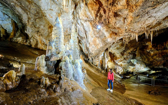 Tourist exploring stalagmites inside Lipa Cave, Cetinje.