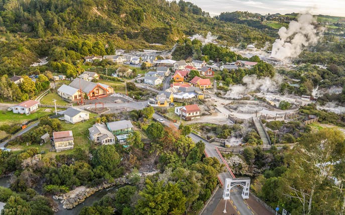 Whakarewarewa Village aerial view with geothermal steam, Rotorua, New Zealand.