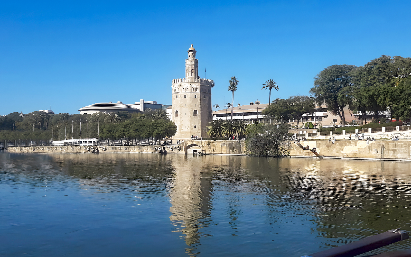 Torre del Oro by the Guadalquivir River in Seville, Spain, with clear blue sky.
