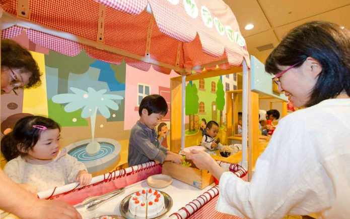 Children playing at a market stall in Kids Plaza Osaka.