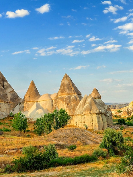 Rock formations in Love Valley, Göreme Cave City, Cappadocia, Turkey under a blue sky.