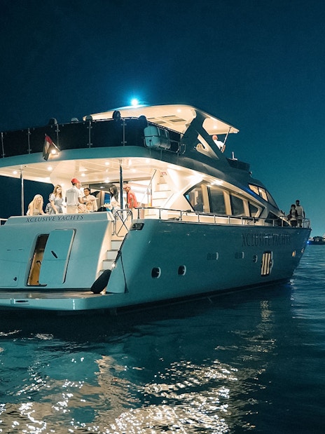 Luxury yacht cruise at night near Burj Al Arab, Dubai.