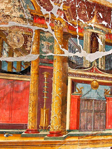 Ancient fresco with ornate columns in Pompeii, Italy, part of Artecard Campania tour.