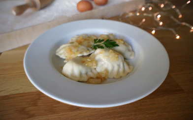 Polish dumplings with onions on a plate during a cooking class.
