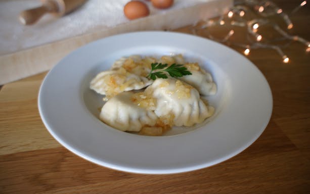 Polish dumplings with onions on a plate during a cooking class.
