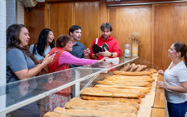 Tourists sampling fresh bread at a bakery in Boston.