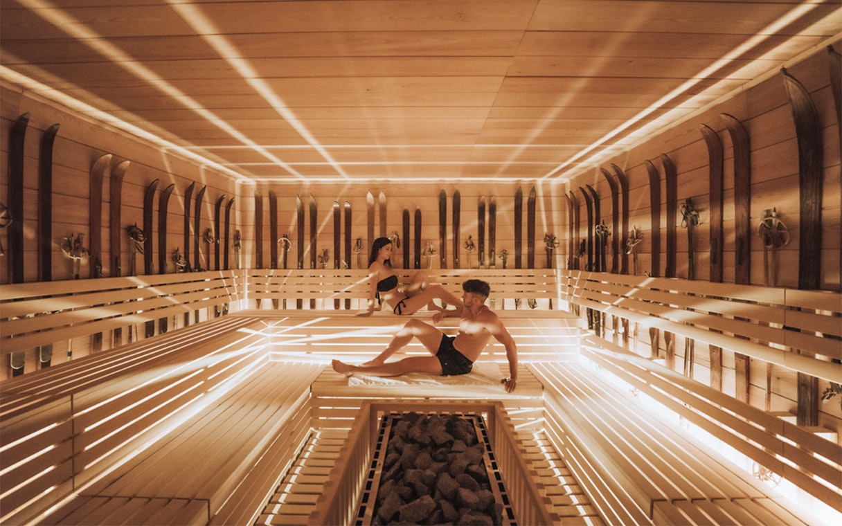 Visitors relaxing in a wooden sauna at QC Terme Chamonix Resort & Spa.