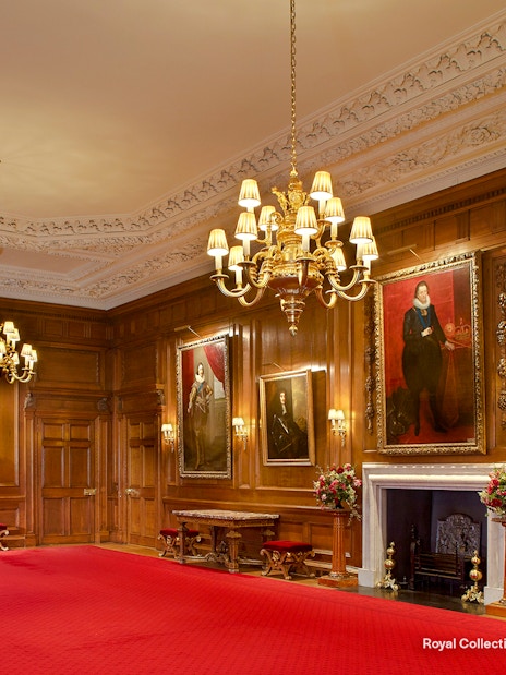 Throne Room at the Palace of Holyroodhouse with portraits and ornate chandelier.