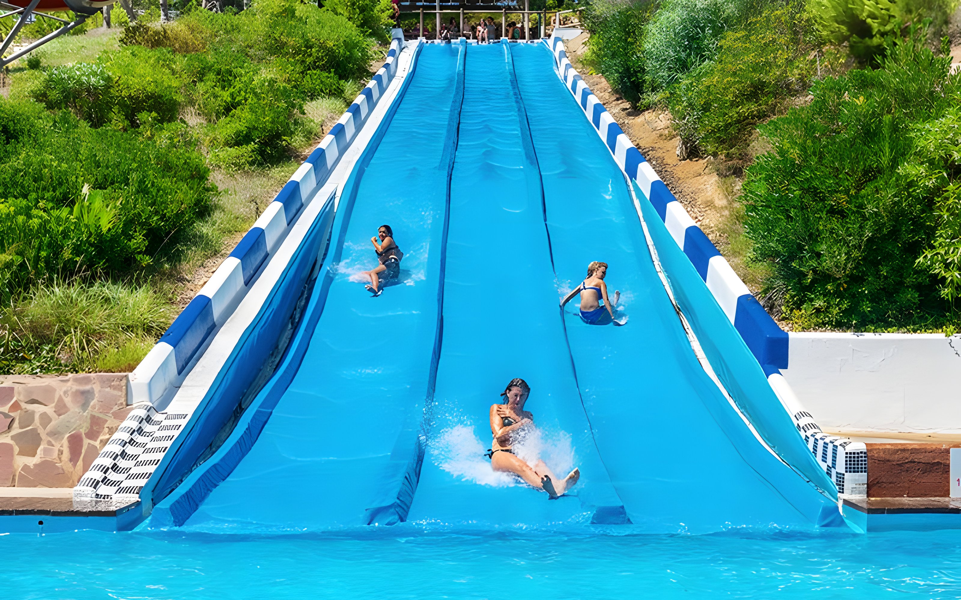 Participants racing down water slides at Aquopolis Cullera.