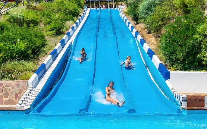 Participants racing down water slides at Aquopolis Cullera.