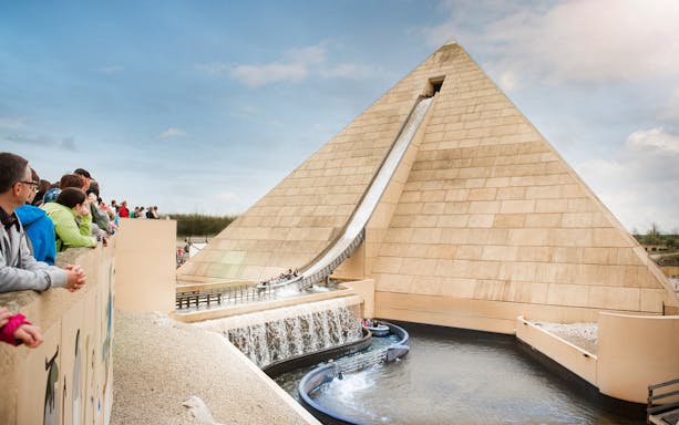 Visitors watching a water ride at Belantis Adventure Park with a pyramid backdrop.