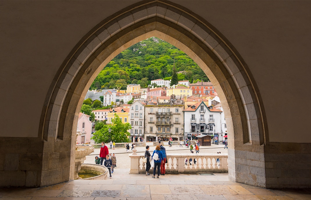 People exploring Sintra City Square with colorful buildings and cobblestone streets in the background.